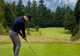 Man playing golf on a golf course in the mountains of Graubünden