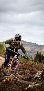 Mountainbiker fährt einen Trail bei Lenzerheide hinunter – Active XS Zwischensaison