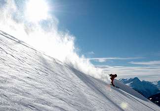 Skier carving down a freshly groomed slope – Early Ski offer in Lenzerheide
