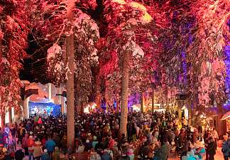 Illuminated squirrel forest at Zauberwald Lenzerheide with live music and crowds in the snow at night