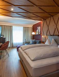 Gemütliches Doppelzimmer mit Holzverkleidung im Hotel – Active XS Übernachtung