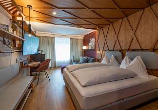 Doppelzimmer mit warmer Holzverkleidung und Bergblick – Active XS Lenzerheide